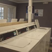 A row of washing machines are lined up in a laundromat.